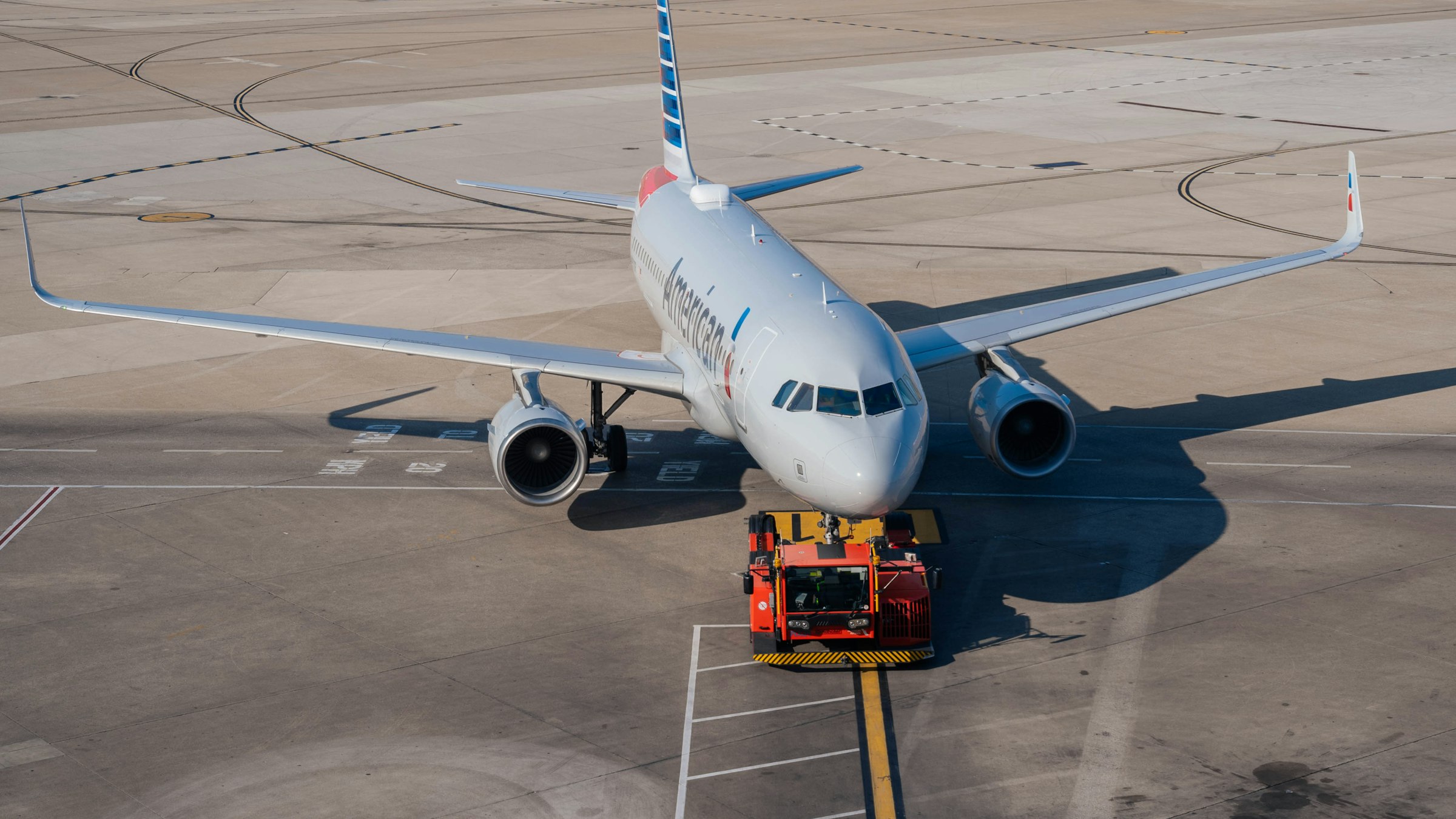 Airport ground support equipment — an aircraft tug pushing back a passenger jet on the tarmac