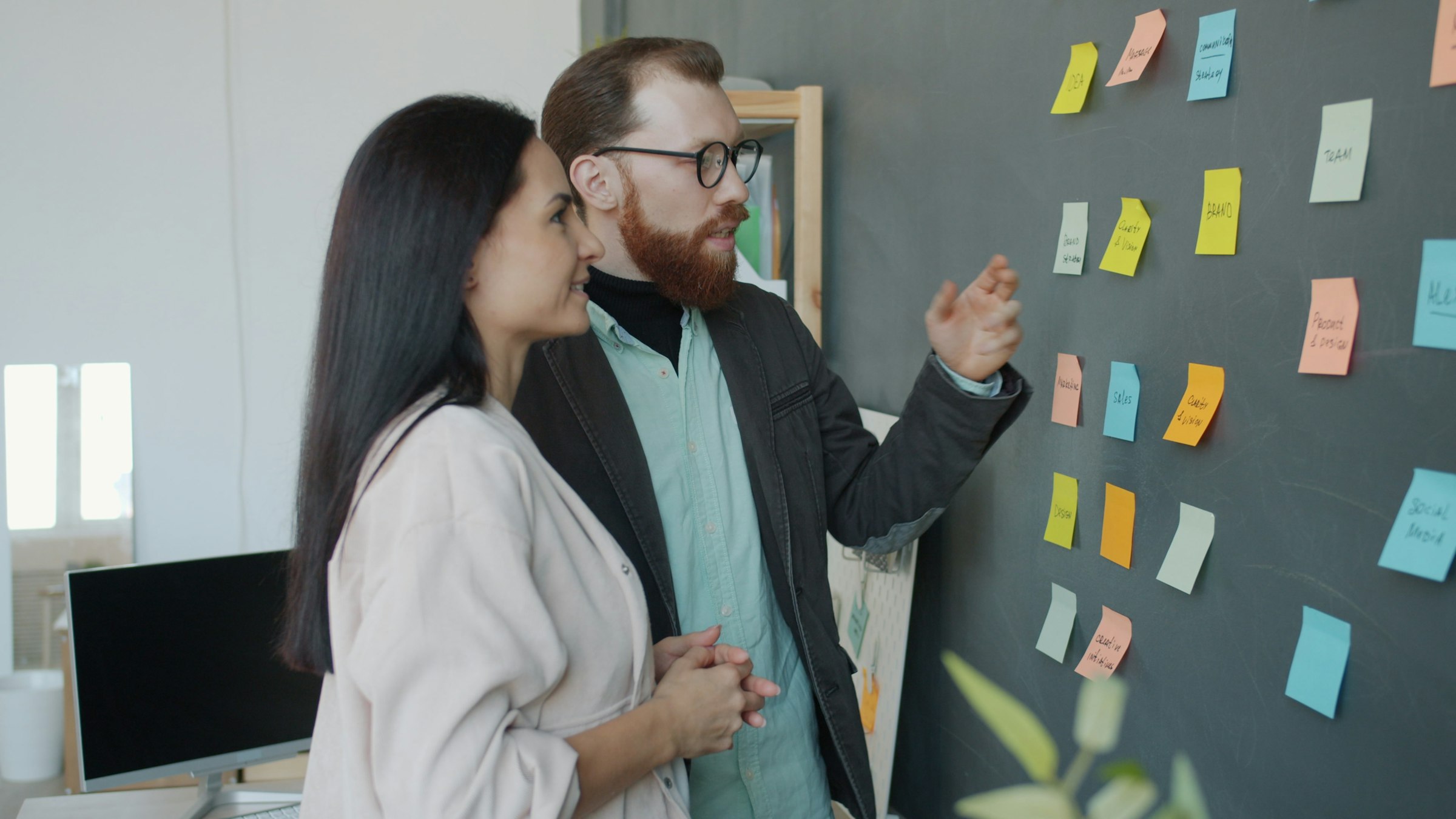 A marketing team mapping out a strategy on a wall of sticky notes